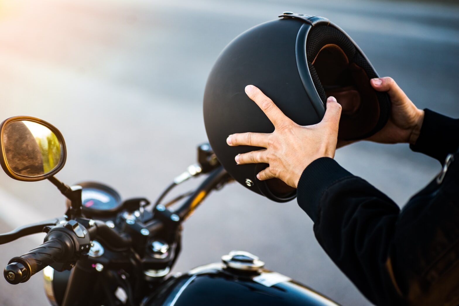 Motorcyclist holding helmet in hands