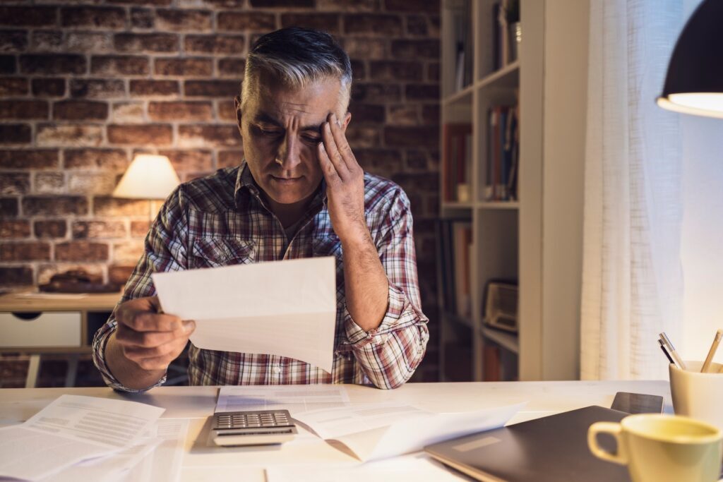 Worried man checking his bills at home
