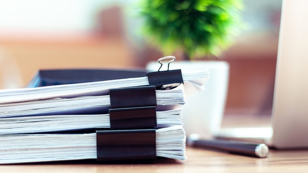 Stack of documents placed on a business desk in an office.