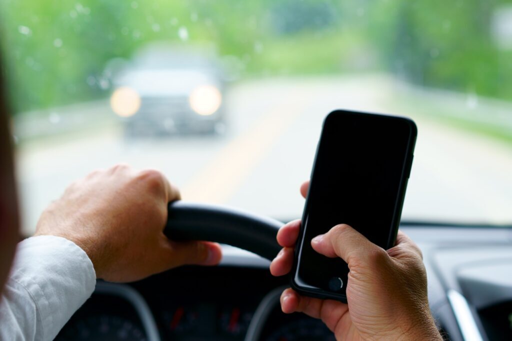 A man is texting while driving.