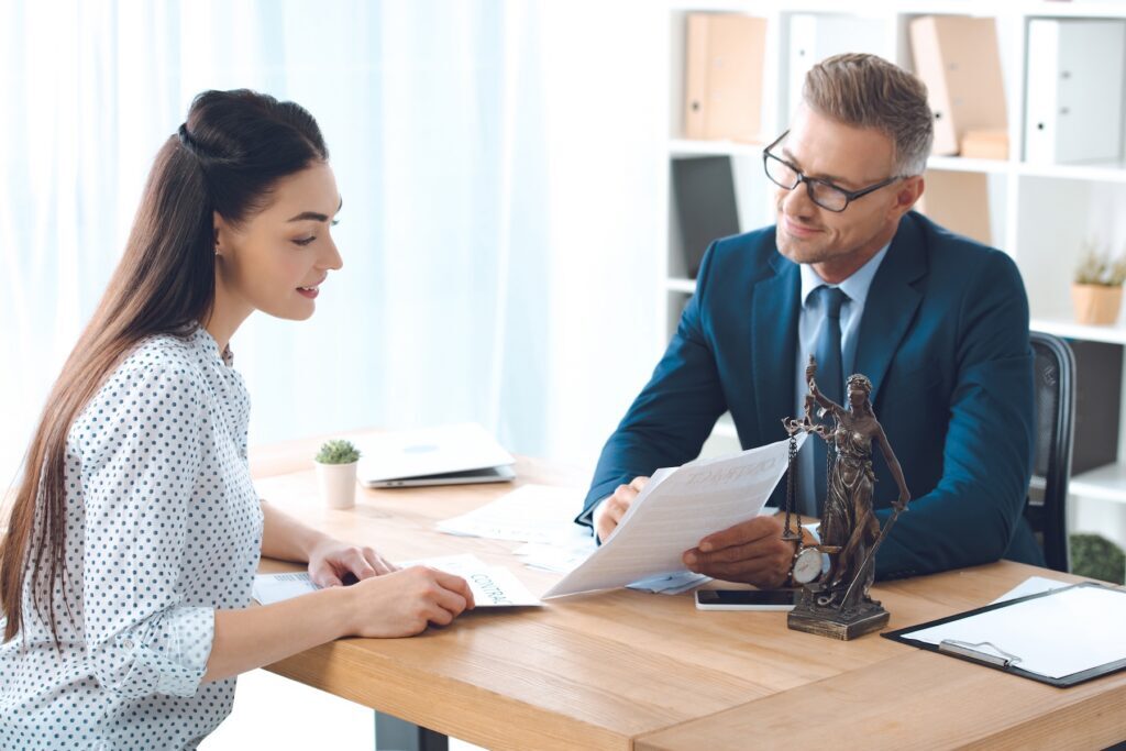 Smiling lawyer showing papers to happy female client in office