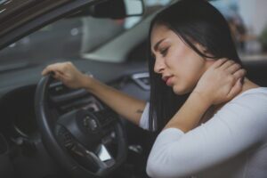 Young woman having terrible neck pain after whiplash injury in car crash.